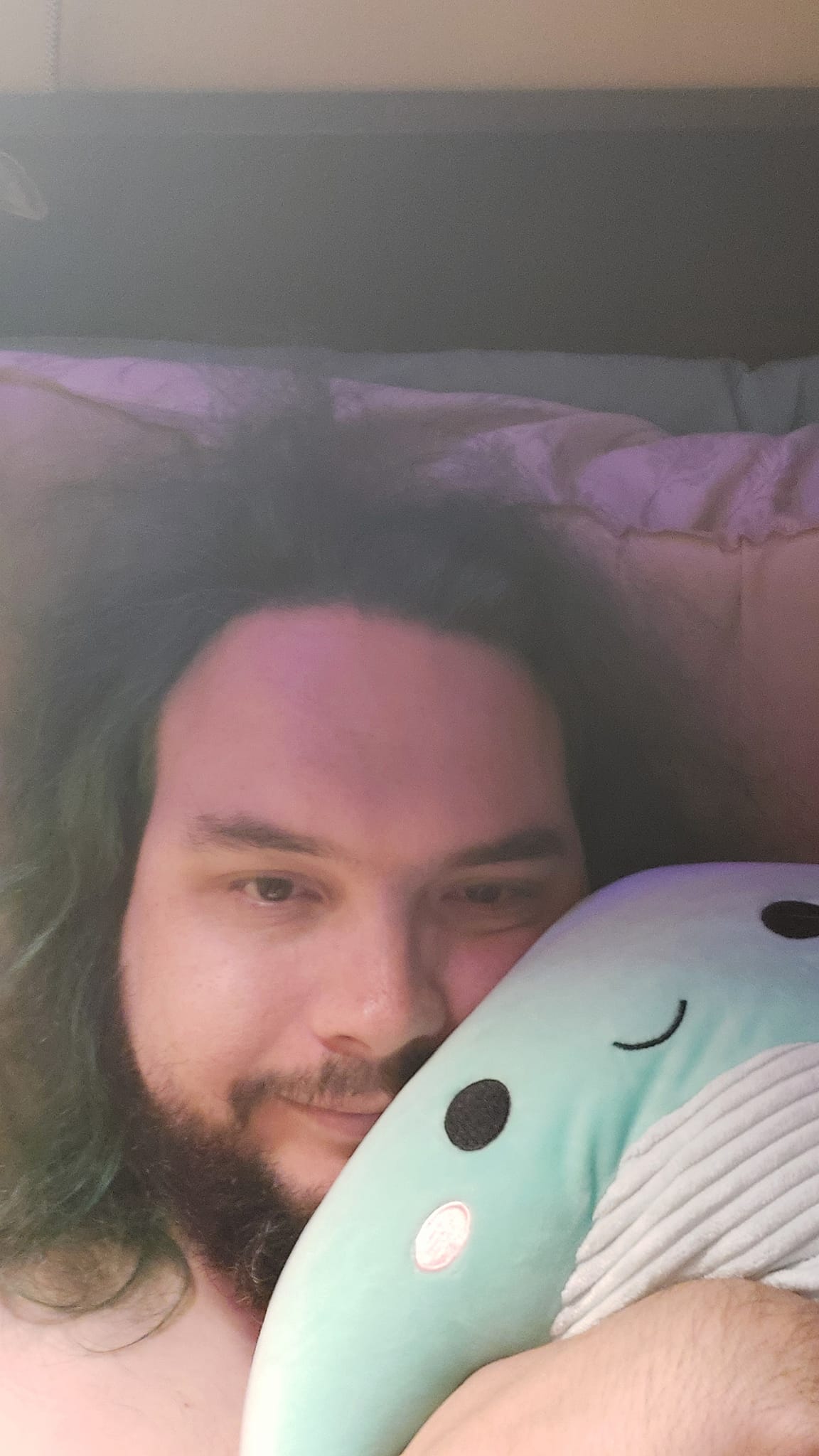 A man with green hair is holding a green Nessie Squishmallow, photo 4